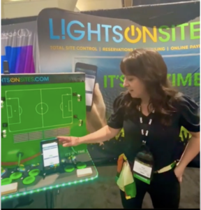 Amy Phillips stands in front of a live demo of LightsOnSites at the CPRS show